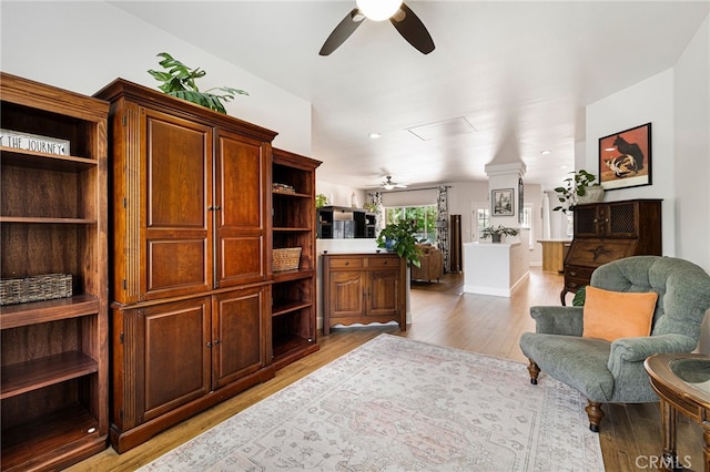 living area with ceiling fan and light wood-style flooring