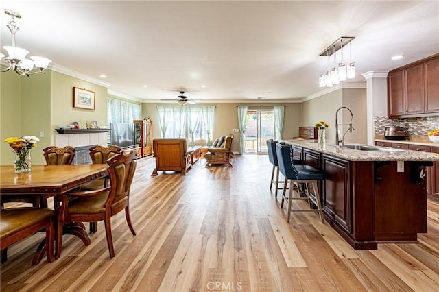 dining space with crown molding, a wealth of natural light, and light wood-style floors