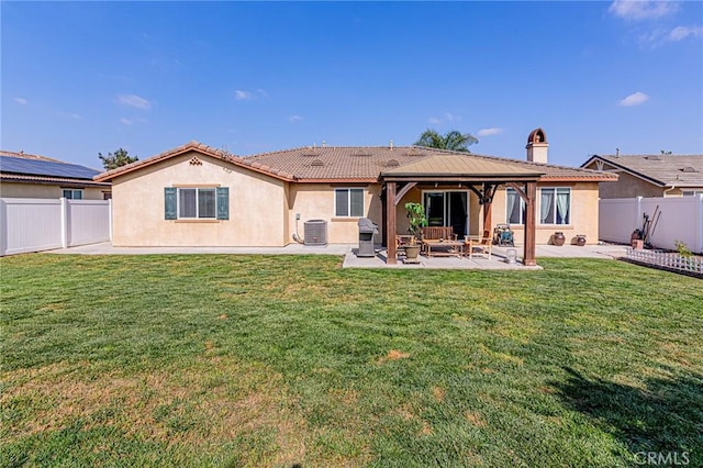rear view of house with a patio, a gazebo, a lawn, stucco siding, and a fenced backyard