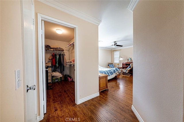 corridor with crown molding, baseboards, and dark wood-type flooring