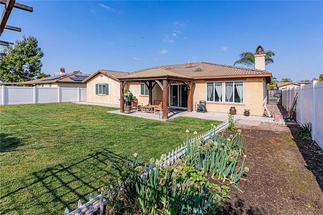 rear view of house with a patio, a fenced backyard, a lawn, a gazebo, and stucco siding