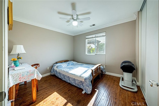 bedroom with ornamental molding, visible vents, wood finished floors, and baseboards