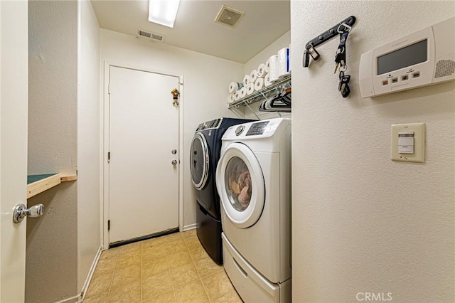 laundry room featuring baseboards, visible vents, separate washer and dryer, and laundry area