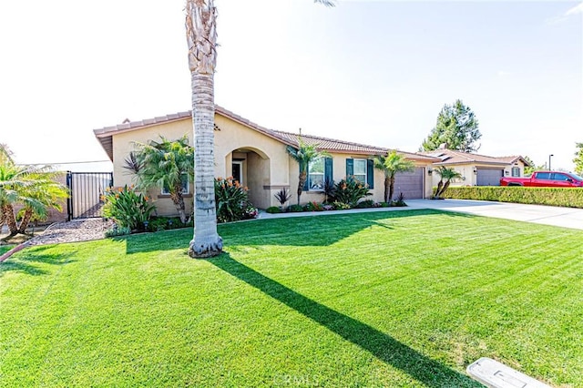 view of front of house with driveway, fence, an attached garage, stucco siding, and a front lawn