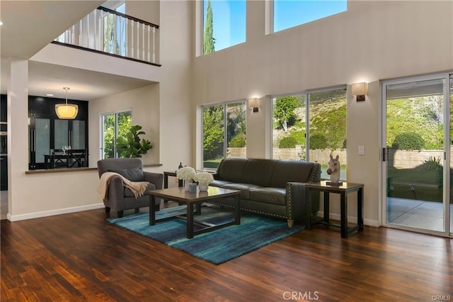 living room featuring baseboards, wood finished floors, and a wealth of natural light