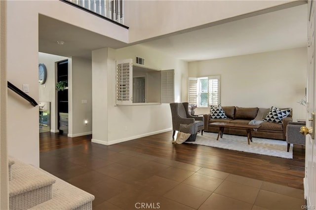 tiled living area with stairway, visible vents, and baseboards
