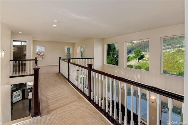 hall with recessed lighting, carpet, and an upstairs landing