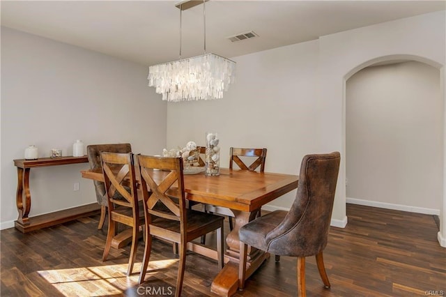 dining room with an inviting chandelier, wood finished floors, visible vents, and arched walkways