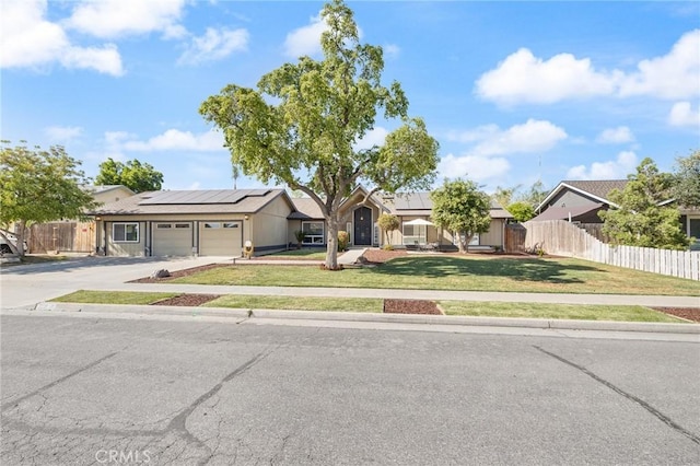 344 E Birch Ave, Hanford, CA 93230 - ranch-style home with a garage, solar panels, a front lawn, and fence