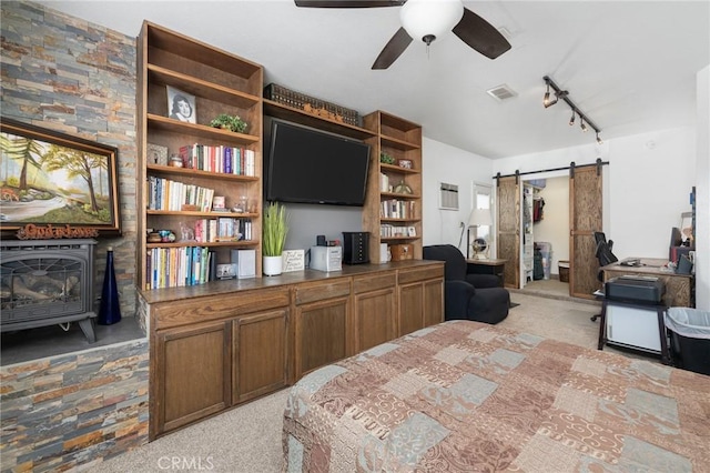 344 E Birch Ave, Hanford, CA 93230 - bedroom featuring a barn door, a wood stove, light colored carpet, rail lighting, and visible vents