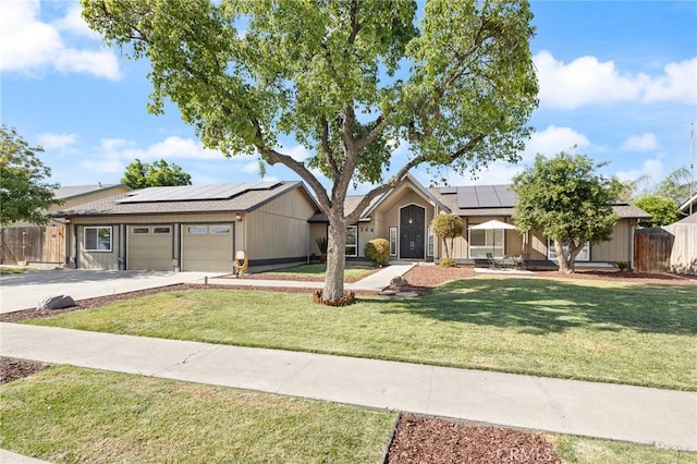 344 E Birch Ave, Hanford, CA 93230 - single story home featuring roof mounted solar panels, a front lawn, fence, and a garage