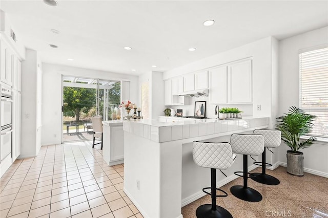 2811 Westbourne Pl, Rowland Heights, CA 91748 - kitchen featuring recessed lighting, light countertops, a breakfast bar, a peninsula, and white cabinetry