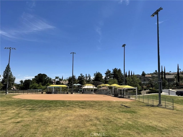 view of community featuring a lawn and fence