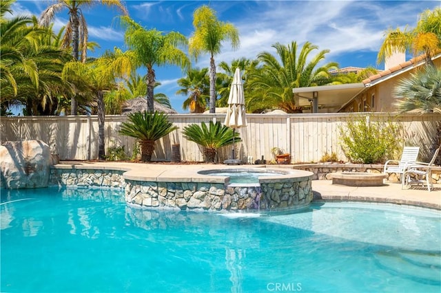 view of swimming pool with fence, a patio, a fenced in pool, and an in ground hot tub