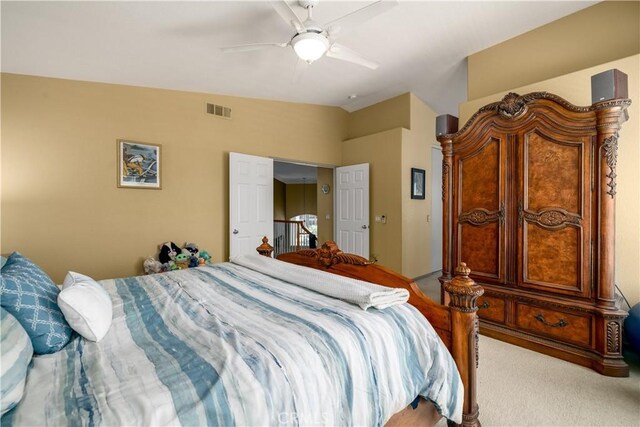 carpeted bedroom featuring vaulted ceiling, a ceiling fan, and visible vents