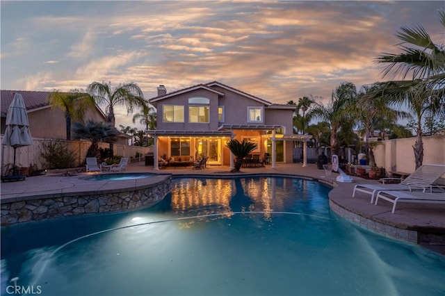 view of swimming pool featuring a fenced backyard, a pergola, a patio area, and a pool with connected hot tub