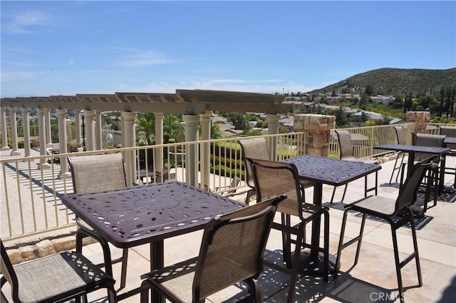 view of patio with a mountain view, outdoor dining space, and a pergola