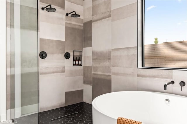 full bath featuring tile walls, a freestanding tub, and tiled shower