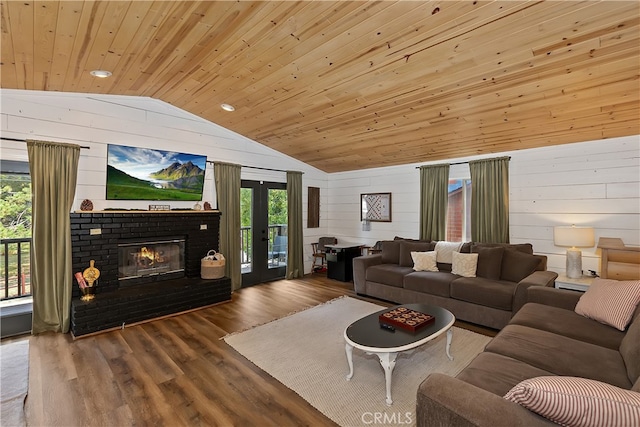 living area featuring lofted ceiling, wooden walls, wood finished floors, wood ceiling, and a brick fireplace