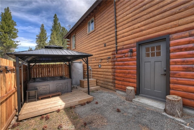 view of side of home with fence, a gazebo, and log exterior
