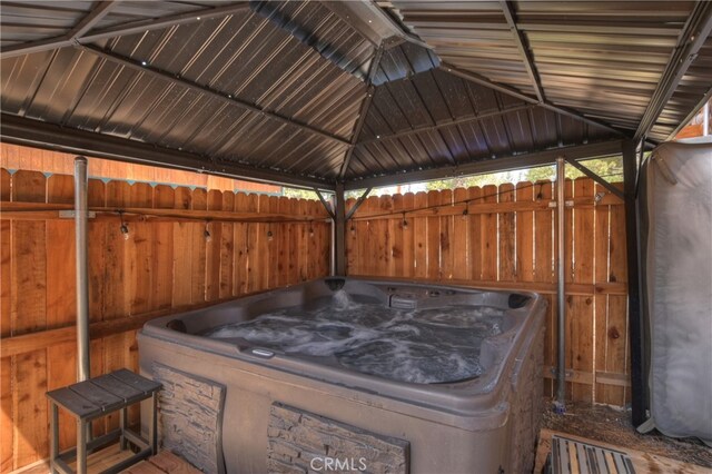 view of patio featuring fence, a hot tub, and a gazebo