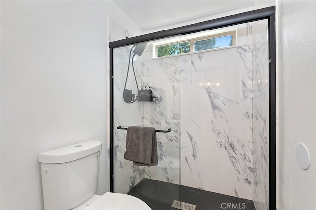 bathroom featuring visible vents, toilet, and a marble finish shower