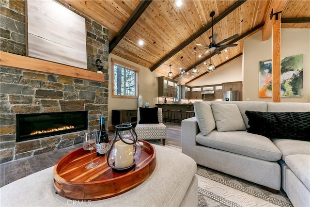 867 Clement St, South Lake Tahoe, CA 96150 - living room featuring a wooden ceiling with exposed beams, wood finished floors, a stone fireplace, high vaulted ceiling, and ceiling fan