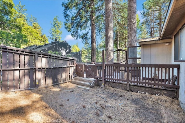 view of yard featuring a wooden deck and fence