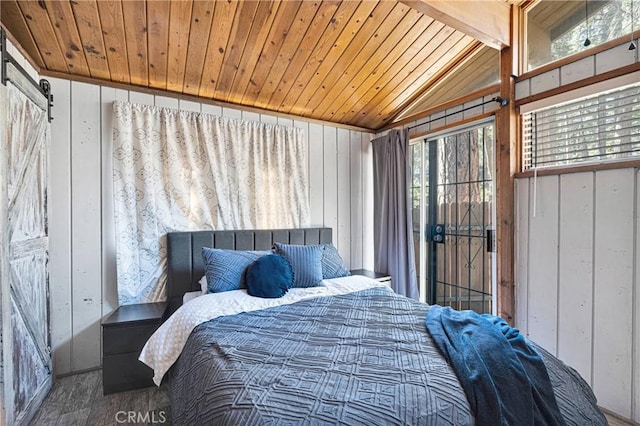 bedroom with a barn door, vaulted ceiling, wood finished floors, wood walls, and wooden ceiling