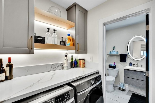 12643 Gladstone Ave, Sylmar, CA 91342 - bathroom featuring washing machine and clothes dryer, vanity, tile patterned flooring, and toilet