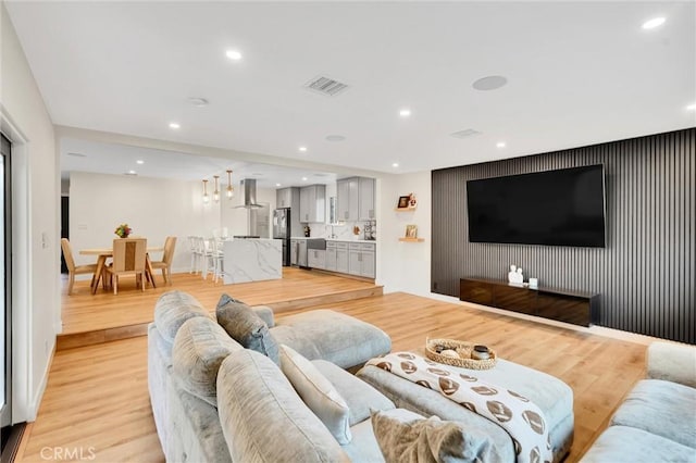 12643 Gladstone Ave, Sylmar, CA 91342 - living room with an accent wall, light wood-style floors, baseboards, visible vents, and recessed lighting