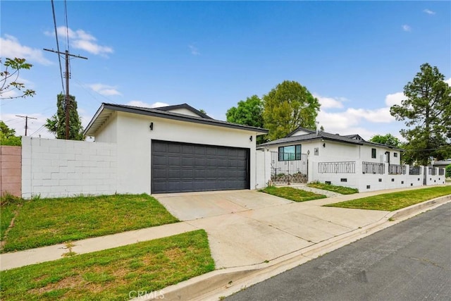 12643 Gladstone Ave, Sylmar, CA 91342 - view of front of property featuring fence, stucco siding, driveway, a front yard, and a garage