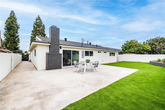 back of house with a chimney, a lawn, a patio area, a fenced backyard, and stucco siding