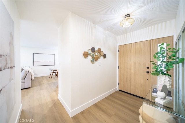 entrance foyer featuring baseboards and wood finished floors