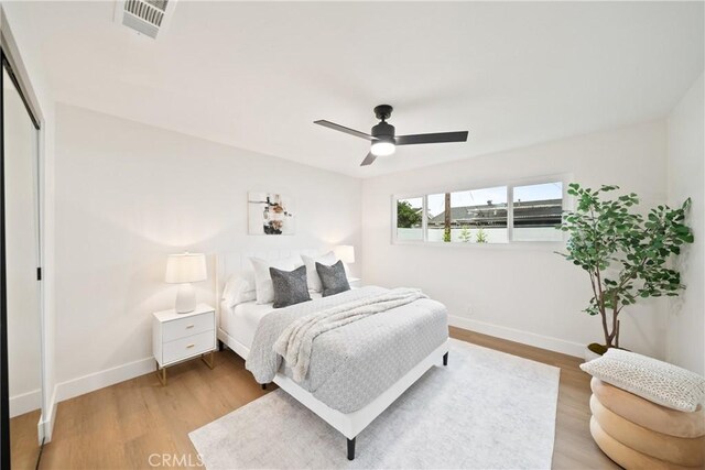 bedroom with baseboards, wood finished floors, and a closet