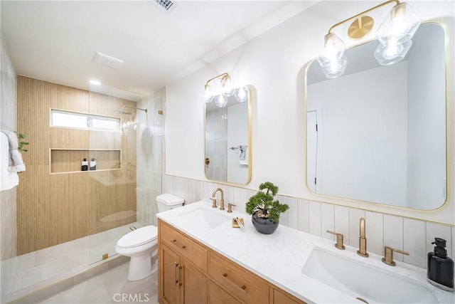 bathroom with a sink, walk in shower, toilet, and visible vents