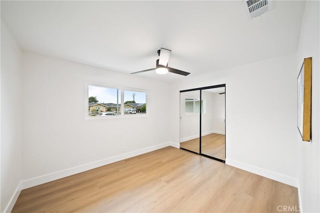 unfurnished bedroom with visible vents, light wood-style flooring, and baseboards
