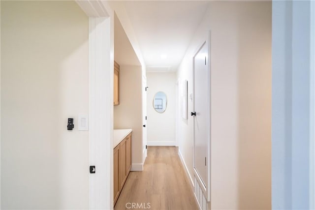 hallway featuring light wood-type flooring, baseboards, and visible vents