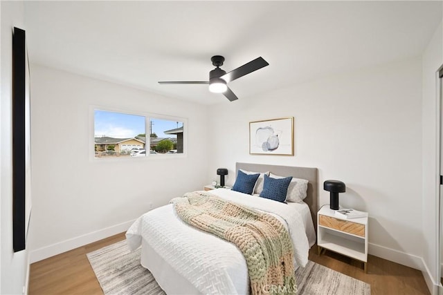 bedroom with baseboards, a ceiling fan, and wood finished floors