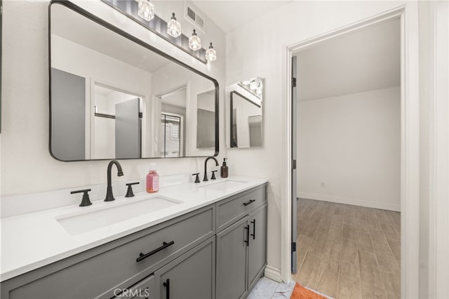 2265 Bradford Ave Unit 516, Highland, CA 92346 - bathroom featuring double vanity, wood finished floors, and baseboards