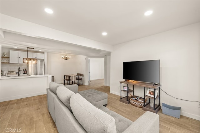 2265 Bradford Ave Unit 516, Highland, CA 92346 - living room featuring recessed lighting, light wood-style flooring, a chandelier, and baseboards