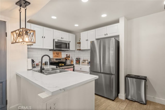 2265 Bradford Ave Unit 516, Highland, CA 92346 - kitchen with appliances with stainless steel finishes, a sink, baseboards, white cabinets, and a peninsula