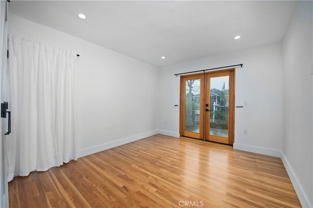 empty room with baseboards, light wood-style floors, and recessed lighting