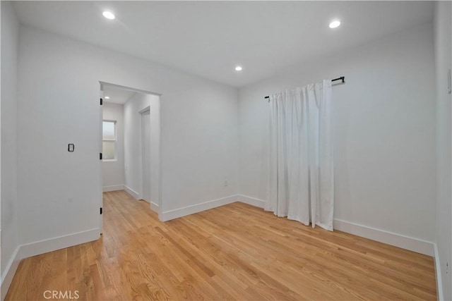 empty room with recessed lighting, light wood-style flooring, and baseboards