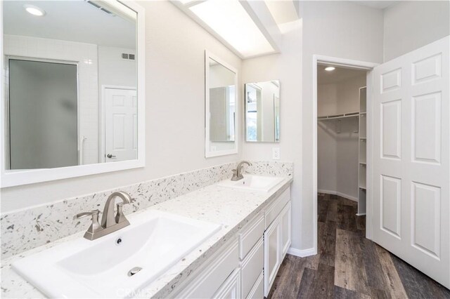 230 Lille Ln Unit 214, Newport Beach, CA 92663 - full bathroom with double vanity, wood finished floors, recessed lighting, and a walk in closet