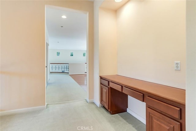 corridor featuring baseboards, recessed lighting, and light colored carpet