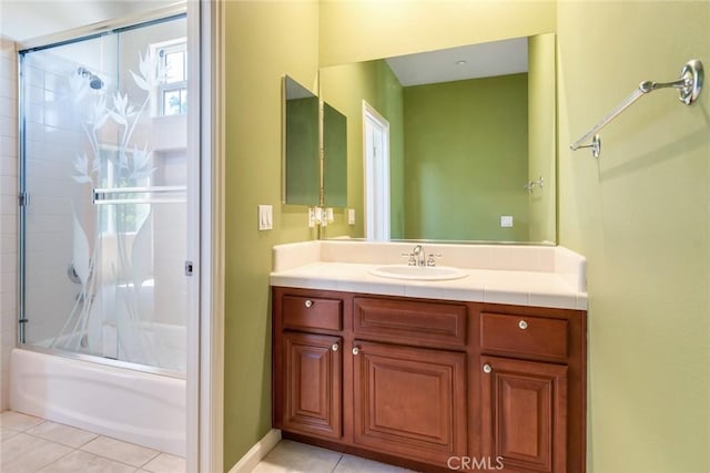 bathroom featuring tile patterned floors, combined bath / shower with glass door, baseboards, and vanity