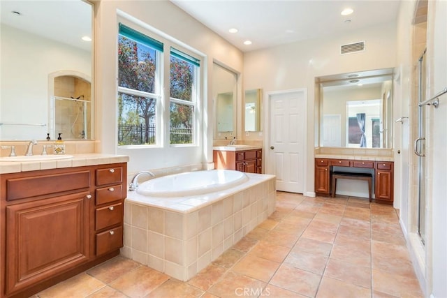bathroom with recessed lighting, a shower stall, a sink, and a garden tub