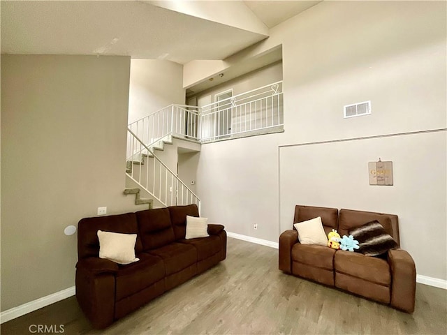 1078 W King St, Banning, CA 92220 - living room featuring stairway, high vaulted ceiling, visible vents, baseboards, and wood finished floors