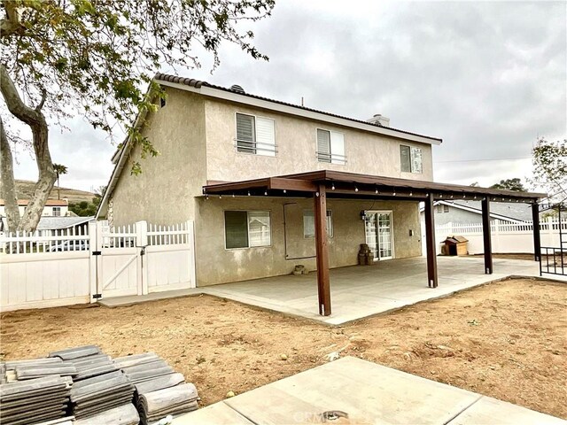 1078 W King St, Banning, CA 92220 - back of house featuring stucco siding, a gate, a patio area, and a fenced backyard